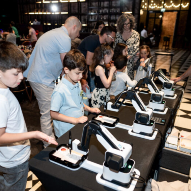 The alternative to a photo booth rental. DrawBots on the tables are engaging with children and adults alike